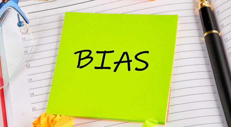 BIAS on a green sticker on the background of an open notebook.