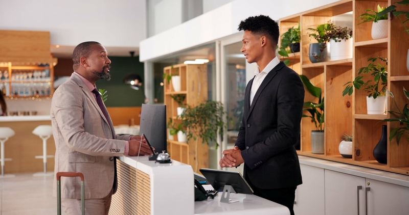 Hotel, lobby and man with receptionist for booking, guest room service and reservation