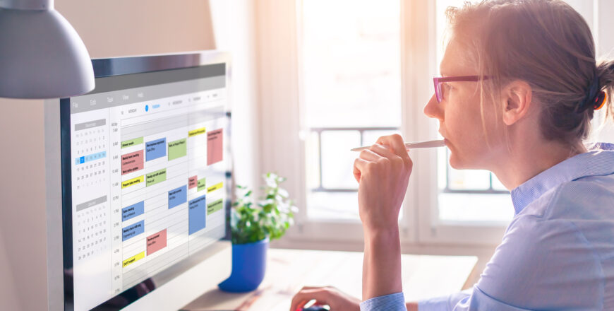 person using calendar on computer to improve time management